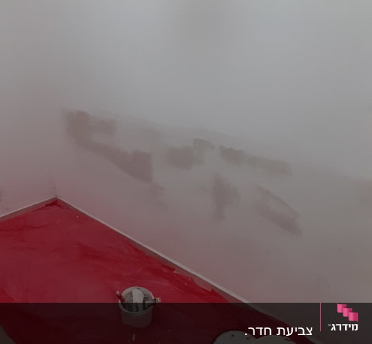 קיר צבוע חלקית עם פחית צבע ומברשות